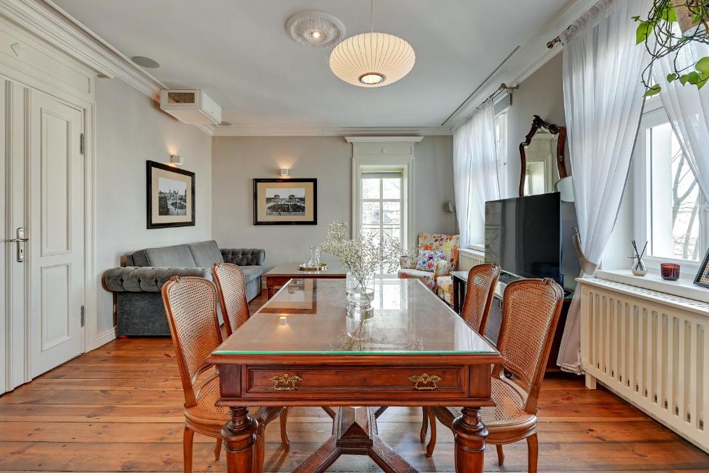 a living room with a table and chairs and a couch at Downtown Apartments Sopot Jagiełły in Sopot