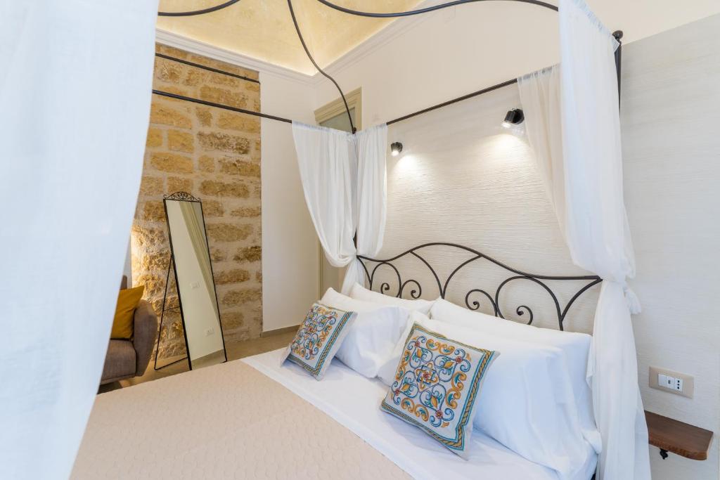 ein Schlafzimmer mit einem großen Bett mit weißen Kissen in der Unterkunft Mama Tita Rooms and Breakfast in Palermo