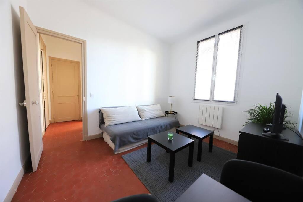 a living room with a couch and a table at Studio boulevard Schloesing in Marseille