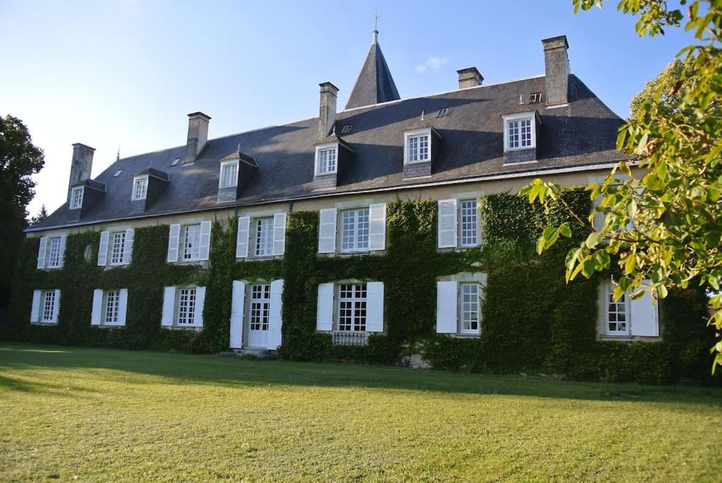 une grande maison avec du lierre sur son côté dans l'établissement La Valette, XVIIs House, Futuroscope, à Saint-Léger