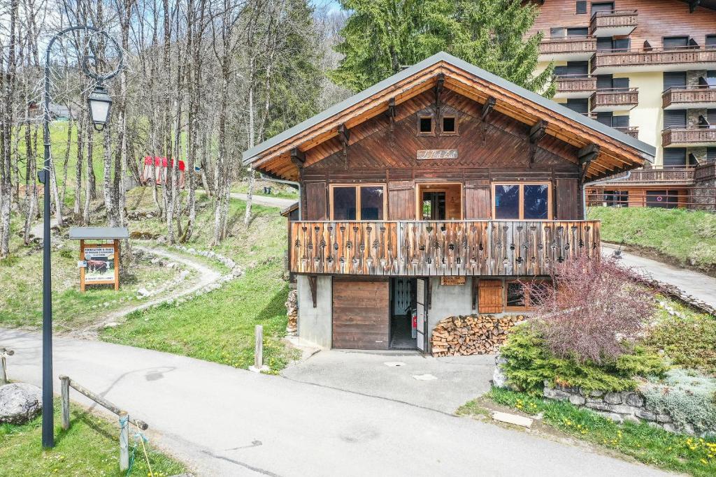 a wooden house with a balcony on a street at Chalet Nid Zut in Châtel
