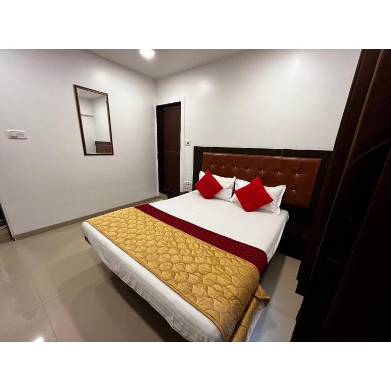 a bedroom with a large bed with red pillows at Hotel Borivali Executive - Near Borivali Railway Station in Mumbai