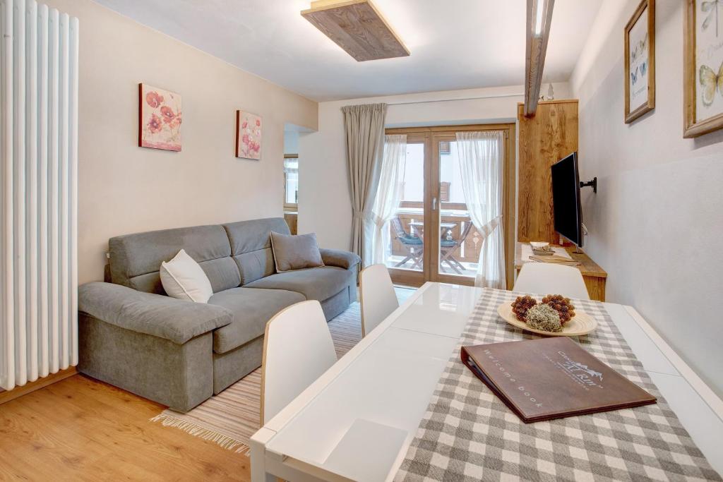 a living room with a table and a couch at Casa Al Rin Ski Bike and Wellness in Valdidentro