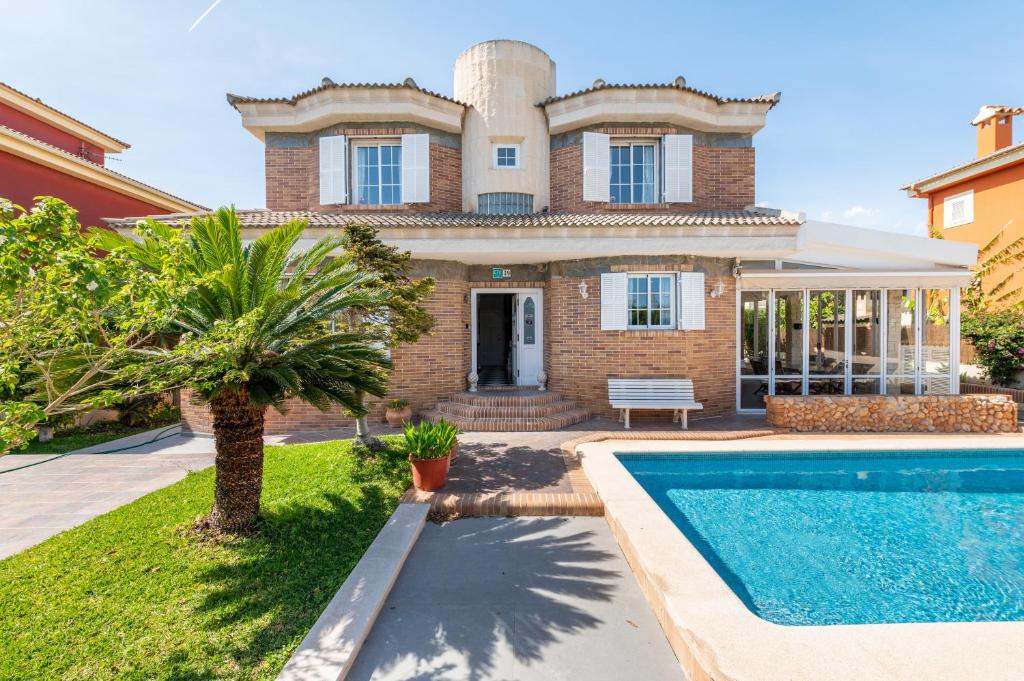 une maison avec une piscine en face de celle-ci dans l'établissement Villa Laura, à Palma de Majorque