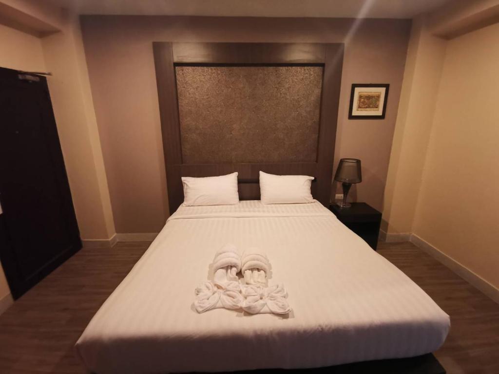 1 dormitorio con 1 cama grande con sábanas blancas en Metro Residence en Surin