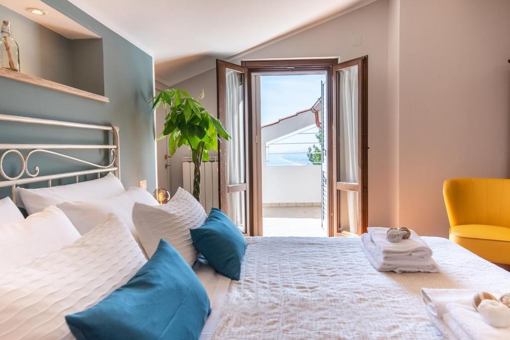 ein Schlafzimmer mit einem großen Bett mit blauen Kissen in der Unterkunft La Ginestra in Fiore Camere in Sirolo