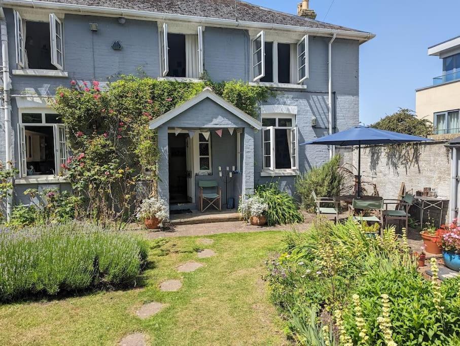 uma casa azul com um pátio e um guarda-chuva em Cliffside em Cowes