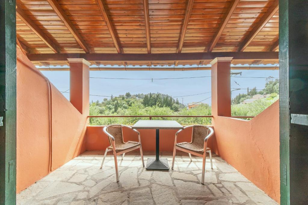 een tafel en stoelen op een balkon met uitzicht bij Arianna Studio Ground Floor 7 in Paleokastritsa