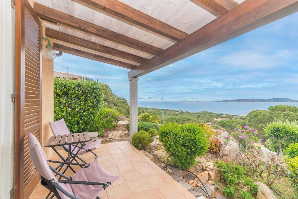 un patio con 2 sillas y una mesa y vistas al océano en Villa Bella, en Santa Teresa Gallura
