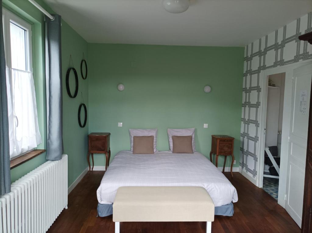 ein Schlafzimmer mit einem weißen Bett und grünen Wänden in der Unterkunft Le Relais des Roses- Chambres d'hôtes in Vatan
