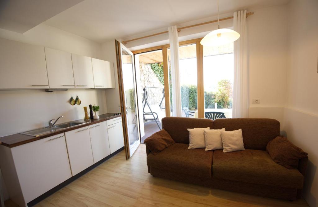 a living room with a couch and a kitchen at Panorama Residence Schlossblick - Apartments Erdgeschoss in Rodengo