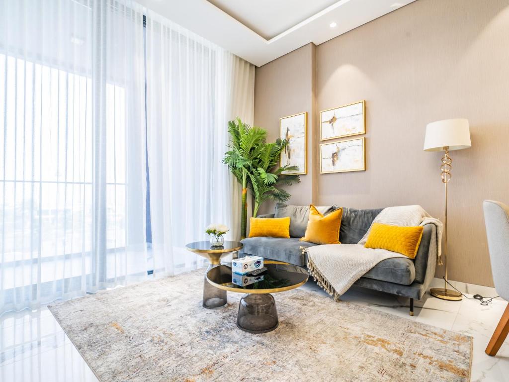 una sala de estar con un sofá y una mesa en Charming Condo With Balcony Near Dubai Hills Park, en Dubái