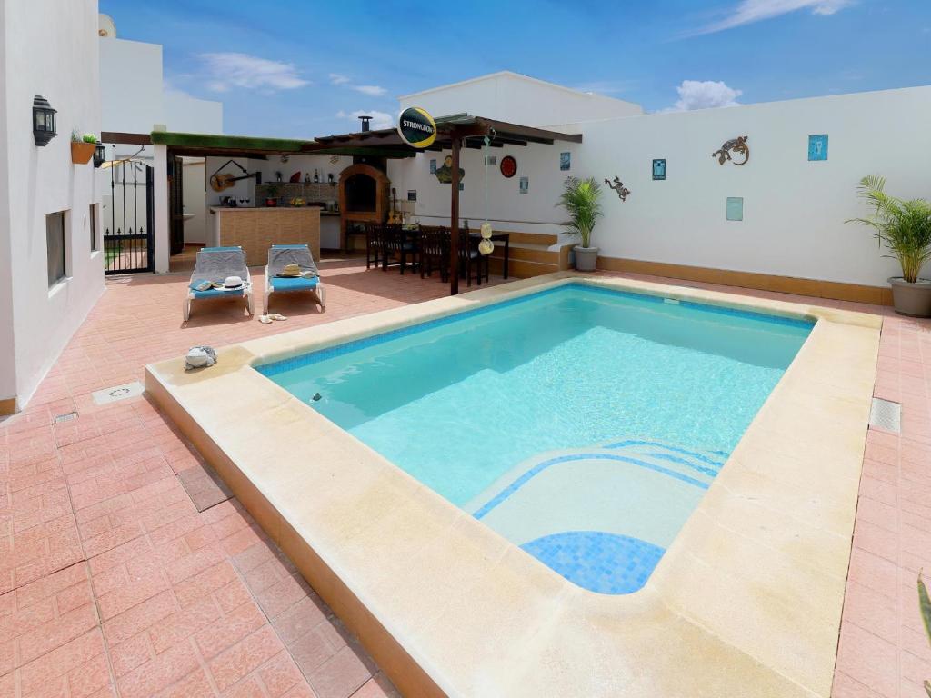 una piscina en un patio con mesa y sillas en Casa Chloe Tias, en Tías