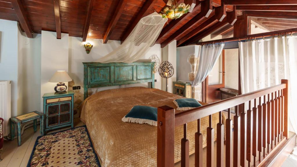 Traditional Cretan Houses,Agios Myronas في أغيوس ميروناس: غرفة نوم بسرير كبير وسقف خشبي