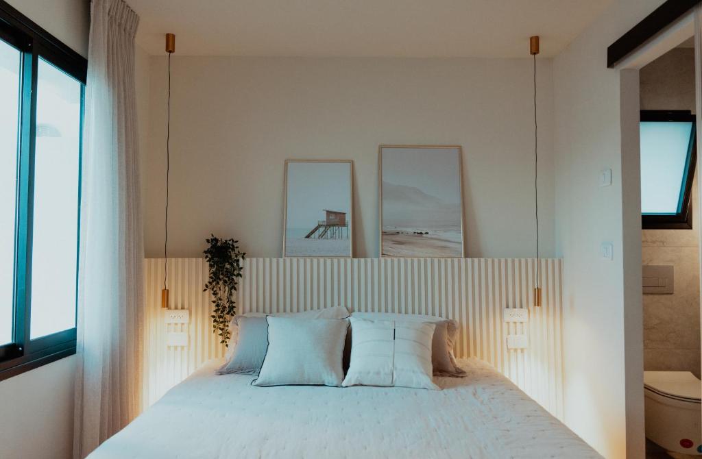 a bedroom with a white bed with two pillows at צימר רפאל in Eilat