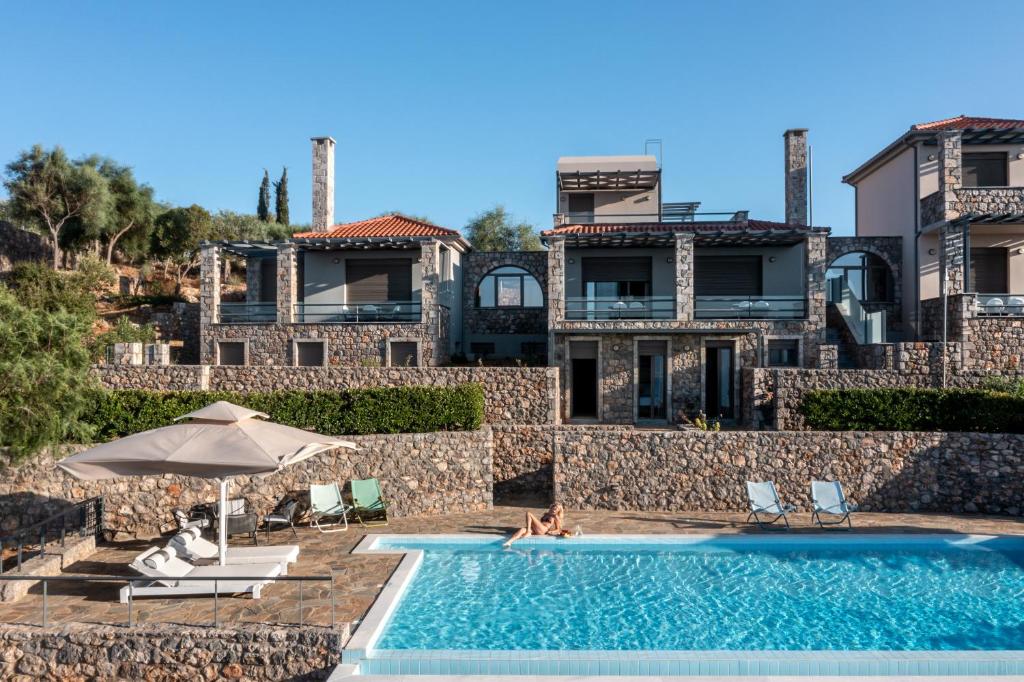 a villa with a swimming pool in front of a building at Searocks Villas Exclusive Resort in Kalamata