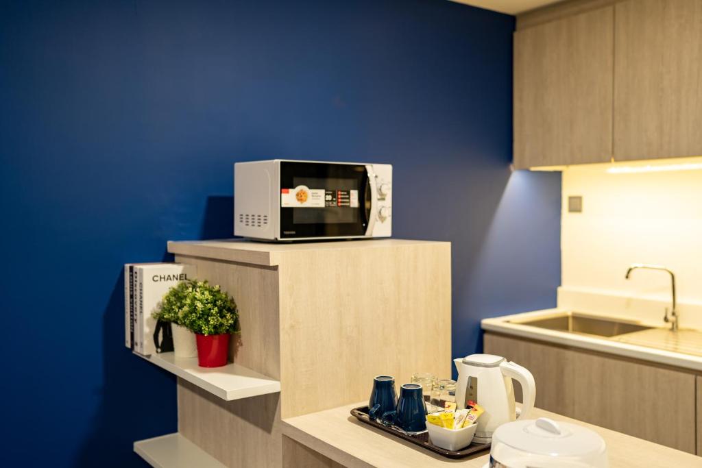 A kitchenette with a microwave, kettle and tea station.