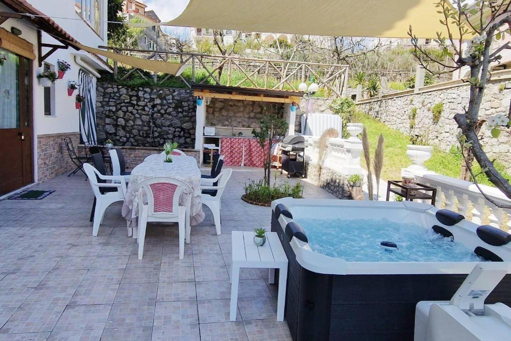 patio con tavolo e vasca idromassaggio di Amalfi Coast Countryside with Jacuzzi and Garden a Polvica