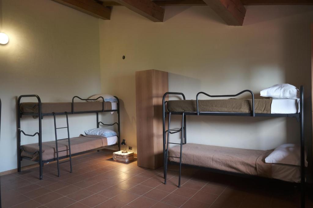 Habitación con 2 literas y suelo de baldosa. en Rifugio Valomagna en Falciano