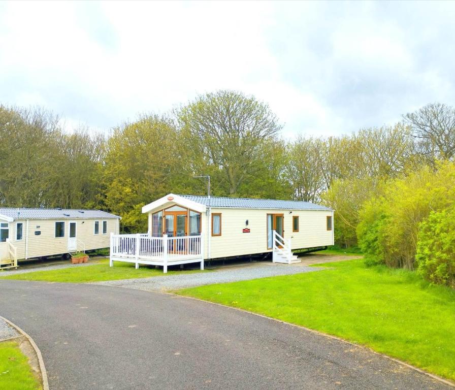 a couple of mobile homes on the side of a road at Sand Le Mere Holiday Village Caravan hire in Tunstall