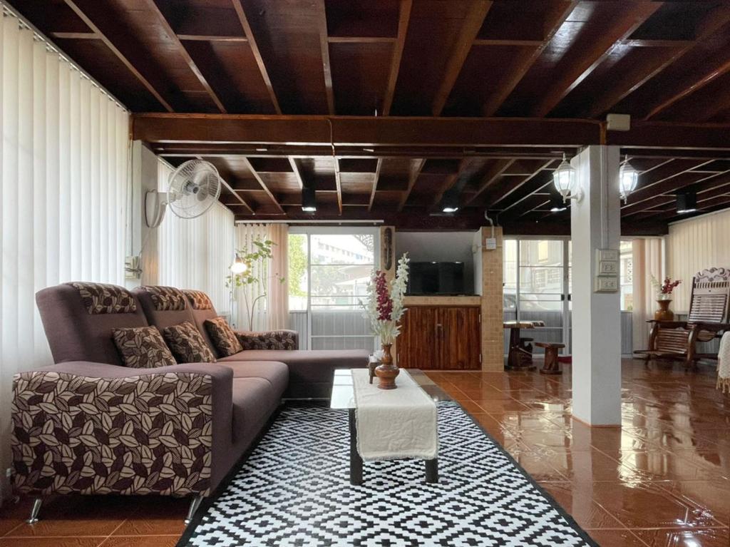 een woonkamer met een bank en een tafel bij Tintin home in Chiang Rai