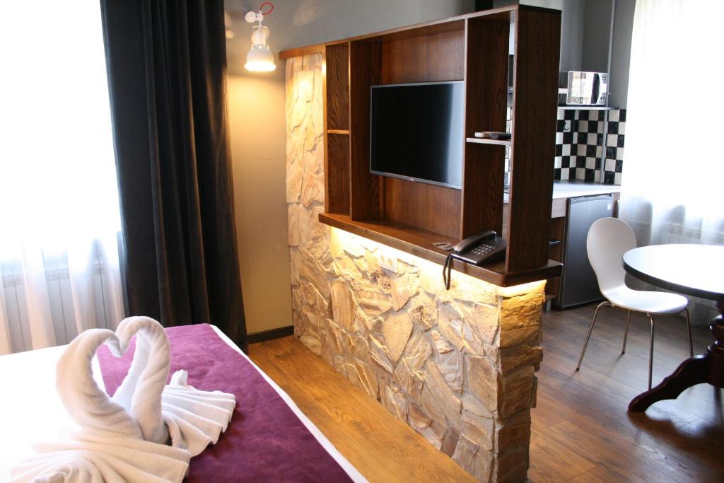 a hotel room with a tv and a bed with towels at Aparthotel in Chişinău
