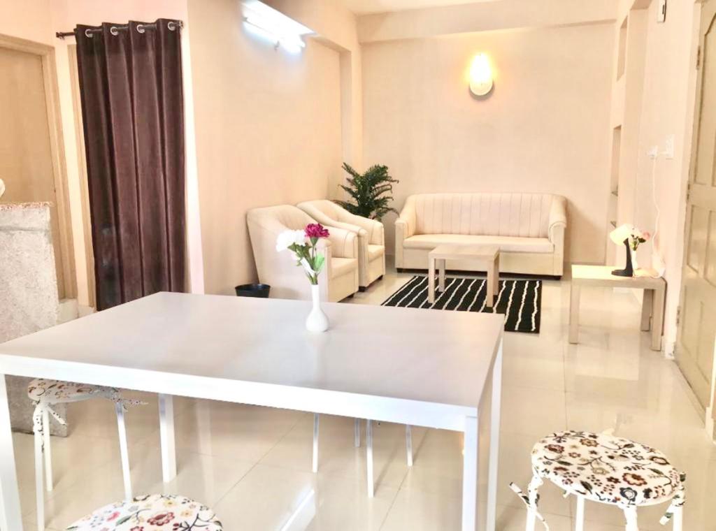 a living room with a white table and chairs at TheReefApartment in Hyderabad