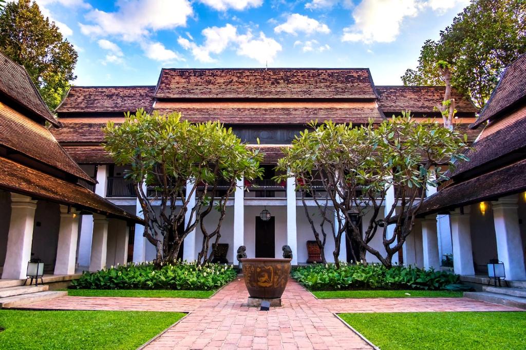 an exterior view of a building with trees at Rachamankha Hotel in Chiang Mai