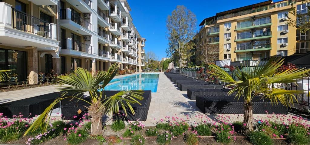 a row of buildings with a swimming pool and flowers at Emilia Romana Park in Sunny Beach