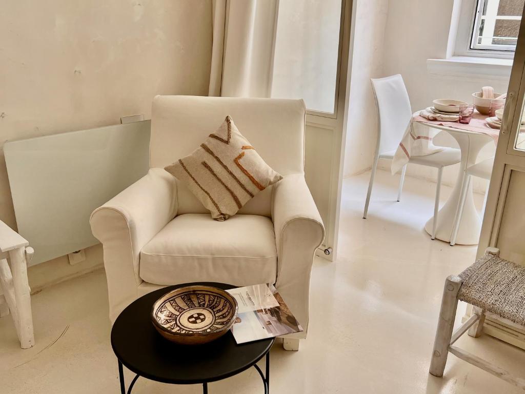 a living room with a chair and a table at La Maison Plume, Appart Boutique in Saint-Rémy-de-Provence