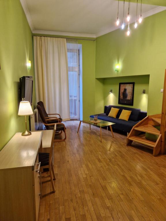 克拉科夫的住宿－Ariadna - Pantheon Apartments，客厅设有绿色的墙壁和蓝色的沙发