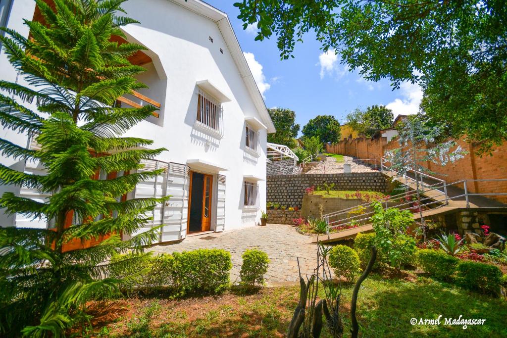 a white house with a courtyard and a tree at An-tsaha Chambre d'hôtes in Fianarantsoa