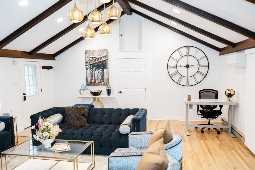 a living room with a blue couch and a clock on the wall at Cowry Acres - The First House Villa w Hot Tub in New Hope