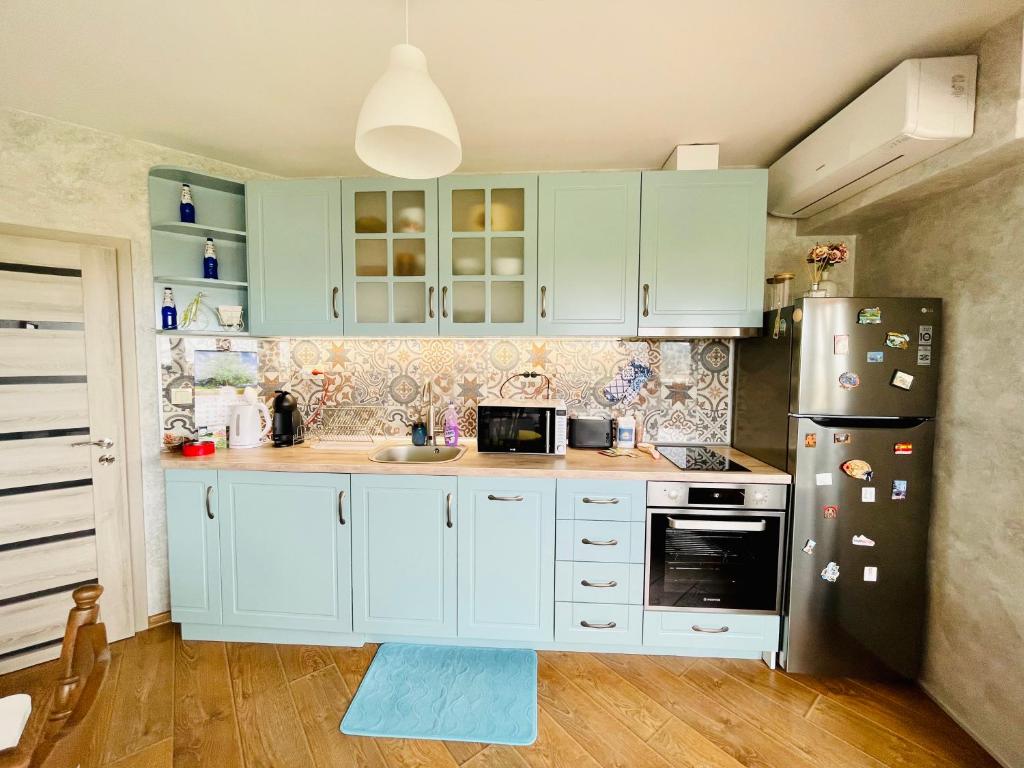 een keuken met witte kasten en een koelkast bij PANORAMA-М in Vratsa