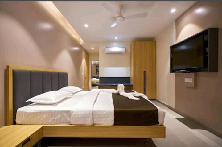 um quarto com uma cama e uma televisão de ecrã plano em Elite Inn, Kolhapur, 100 Mts from Railway Station em Colhapur