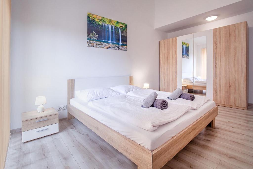 una camera da letto con un grande letto con lenzuola bianche di Apartamenty DM a Kłodzko