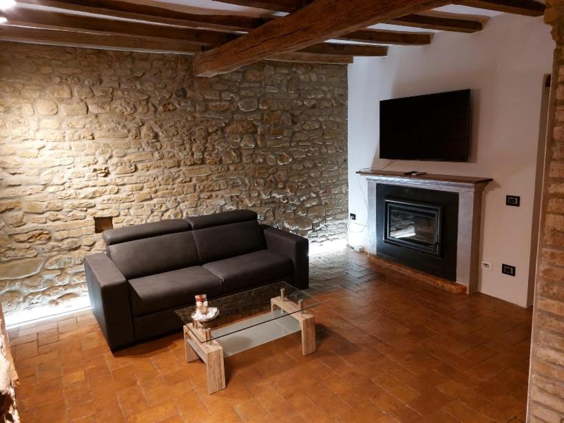 sala de estar con sofá y chimenea en Caolzio18, en CastellʼArquato