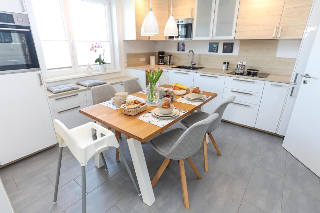 a kitchen with a wooden table and chairs at WEINQUARTIER Bad Kösen 65 qm Küche Parkplatz Terrasse Weinbergsblick in Naumburg