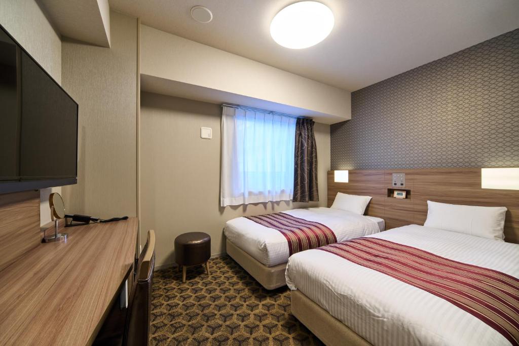 Postel nebo postele na pokoji v ubytování Hotel WBF Namba Motomachi