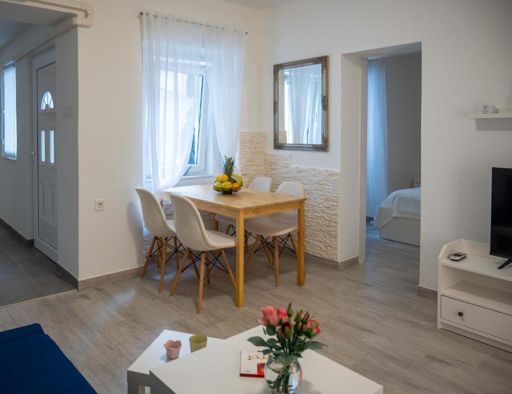 1 dormitorio y sala de estar con mesa y sillas. en Apartment Montona, en Pula