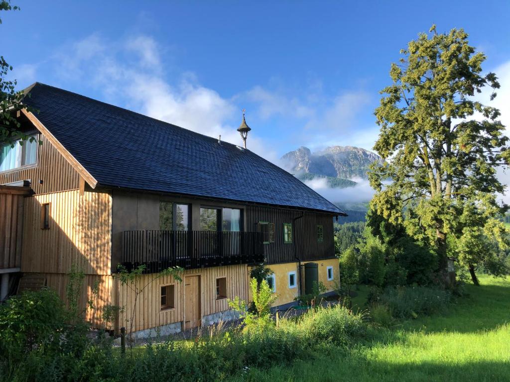 a wooden barn with mountains in the background at Apartment Stillleben Luxus für die Seele in Abtenau