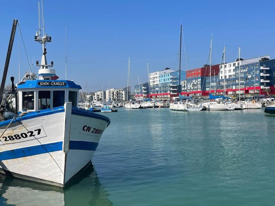 un bateau est amarré dans un port avec d'autres bateaux dans l'établissement Appartement T2 - 50m de la Mer - Parking - Wifi, à Courseulles-sur-Mer