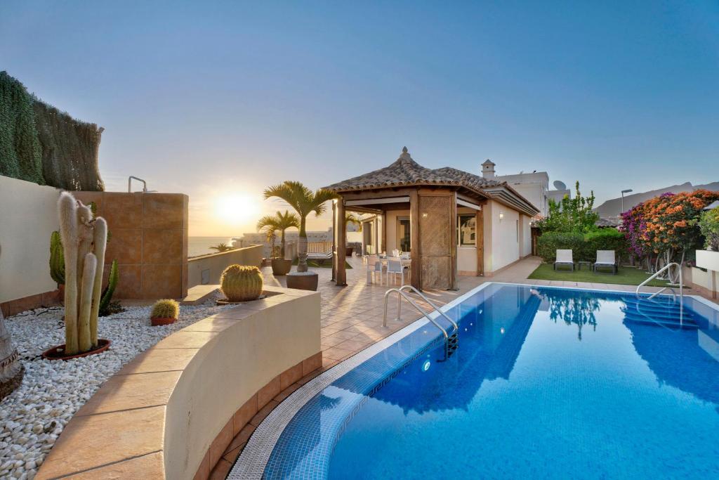 - une piscine dans une arrière-cour avec une maison dans l'établissement Villa Happy Holidays Pool Private, à Puerto de Santiago