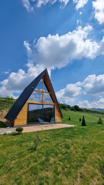 une petite maison avec une grande fenêtre dans un champ dans l'établissement HelenaHouse22, à Ledinci