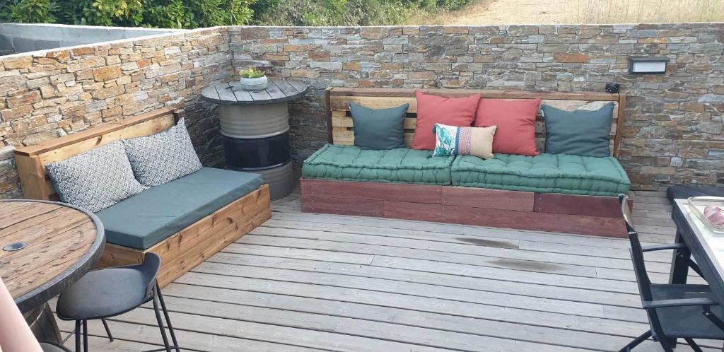 a patio with a couch with pillows on it at Villa T4 avec piscine in Lucciana