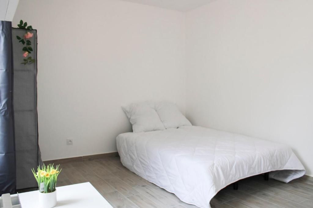 Cama blanca en habitación blanca con mesa en Beautiful apartment of 20 m with terrace, en Ivry-sur-Seine