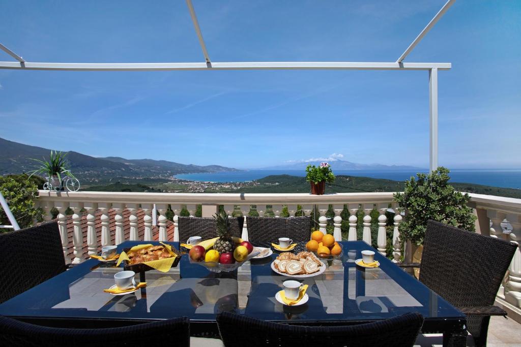 a table with fruit on it on a balcony at Zante Sunset Vibes Luxury Villa in Áno Yerakaríon