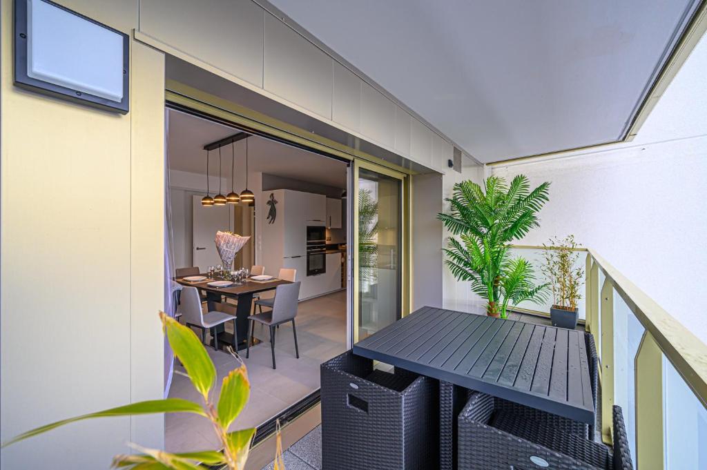 un balcone di una casa con tavolo e sedie di L'Audacieux - Appt neuf avec vue sur les toits a Vannes