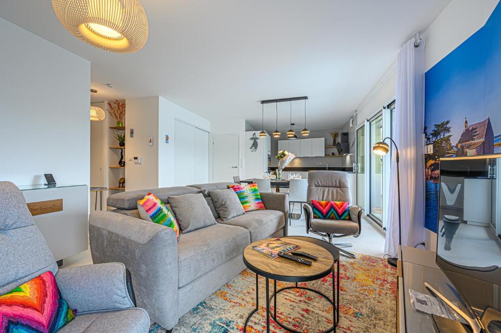 un soggiorno con un divano e un tavolo di L'Audacieux - Appt neuf avec vue sur les toits a Vannes