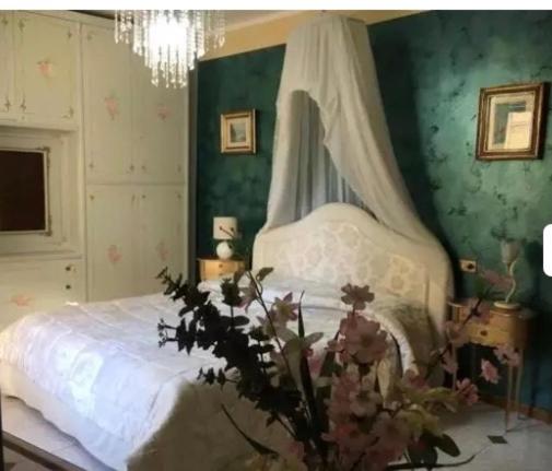 a bedroom with a bed with a canopy and flowers at Massenzio's house in Lecco